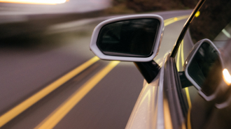Closeup of the rearview mirror of a car on the highway