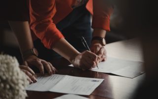 women-signing-documents