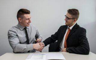 two-men-shaking-hands-paperwork