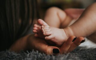 mother-holding-baby-feet-scaled-aspect-ratio-320-200