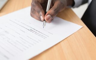 man-signing-document-scaled-aspect-ratio-320-200